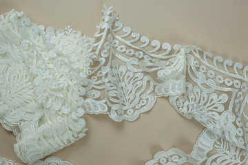 Texture lace fabric. lace on white background studio. thin fabric made of yarn or thread. a background image of ivory-colored lace cloth. White lace on beige background.