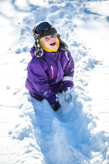 Fototapeta na wymiar Funny cute 5 years old boy playing with snow outdoors