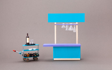 Restaurant service concept. Toy waiter sommelier trolley, bar counter service area. Gray...