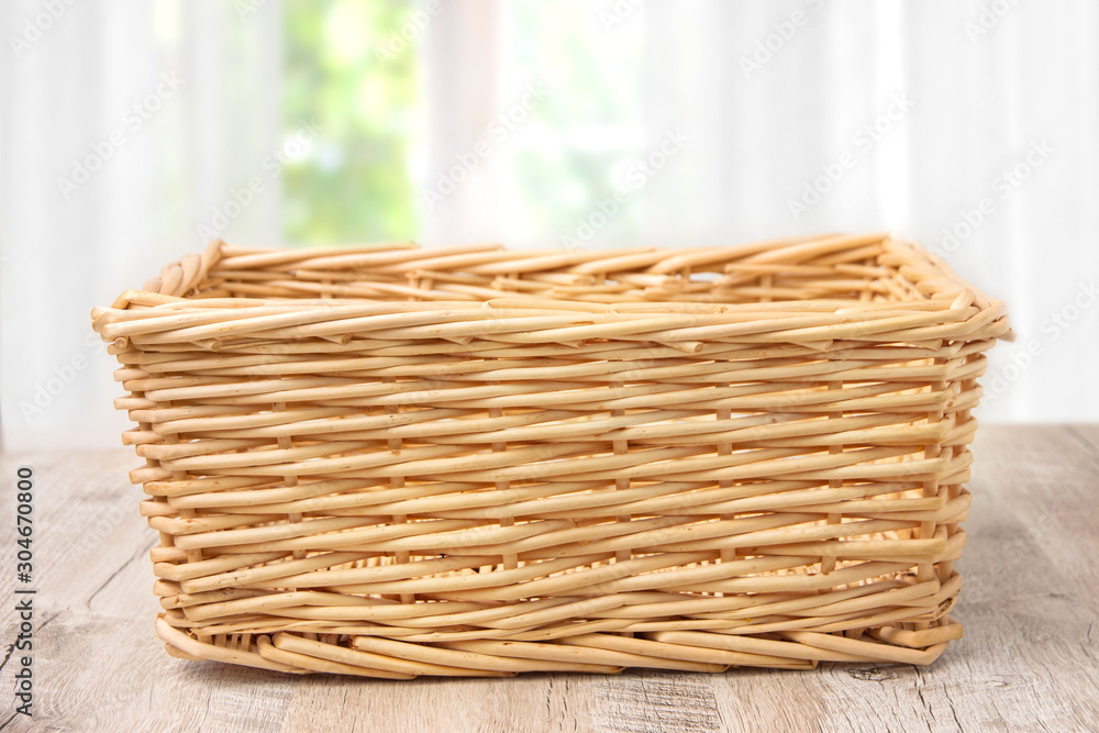 Wall mural Wicker basket on a wooden table