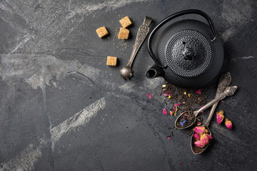 Black japanese cast iron teapot and flower tea with rose buds