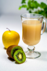 Juicy smoothie from apples and kiwi in a glass cup on a white background