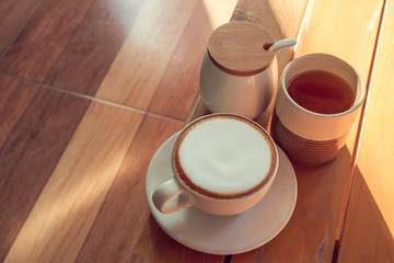 Obraz na płótnie Canvas Cappuccino Cup Tea and sugar cups on a wooden table