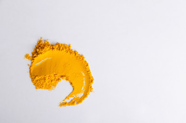 Top view of turmeric powder on the white kithen table, free space