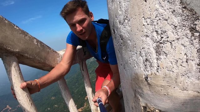 The traveler blogger makes videos for instagram on social networks. He make a dangerous climb to a unique tower 48 meters high located on the Ambuluwawa hill at an altitude of 356 m above sea level.