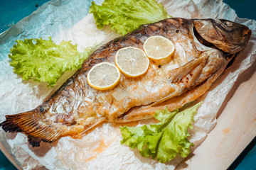 Baked stuffed fish carp with vegetables.