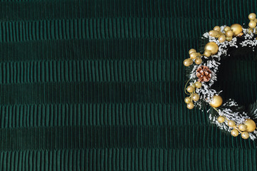 A christmas wreath on green dark textile background with copy space. New year and decorations concept. 