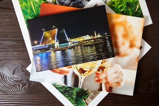 Canvas prints on brown wooden table. Photos with gallery wrap method of canvas stretching on stretcher bar. Colorful photographs printed on glossy synthetic canvas