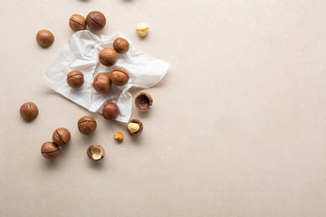 Fresh macadamia nuts on stone background