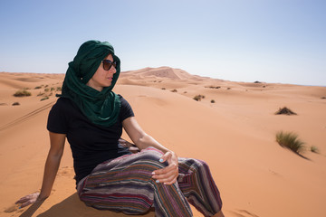 Woman looking at the horizon in the Moroccan Sahara desert.