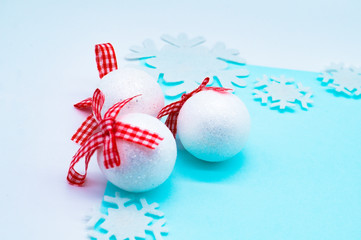 Christmas baubles, white balls with sparkles and snowflakes on a white and blue background. New Year and Christmas background concept. Ball, snowflake, close-up