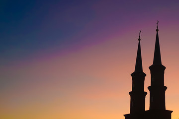 Minarets of the mosque at sunset. Black silhouette of beautiful mosque.
