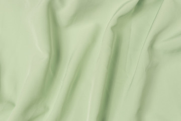 Abstract folds. Delicate silk drapery. Waving light green fabric texture background
