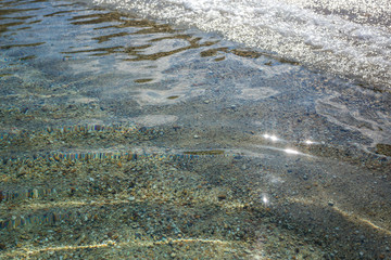 Beautiful clear blue sea water splashing softly at sandy beach of Greece. Horizontal color photography.