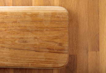 Wooden cutting board on a oak table.