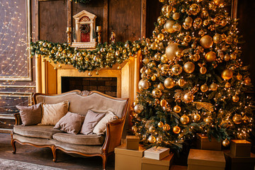 Christmas background with illuminated fir tree with golden decpration and fireplace in living room. Cozy holiday home