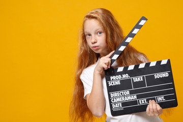 Pretty little ginger kid girl 12-13 years old in white t-shirt isolated on yellow background in...