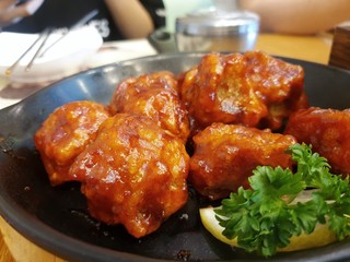Selective focus of fried chicken with spicy sauce on blurred background in restaurant, ready to eat, Space for your text