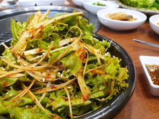 Selective focus of Korean lettuce pickle with sesame in black plate as a background, Kimchi is korea traditional