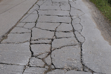 Stark beschädigte Fahrbahn einer Straße in Rumänien / Banat