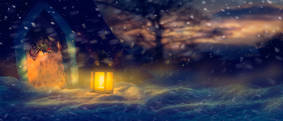 Festive Christmas background scene of a wooden door, wreath and warm glow of a lantern in the snow