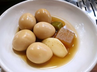 Korean food style, Top view of soy sauce braised quail eggs with cucumber, radish and garlic sliced on white plate, side dishes in Korea restaurant