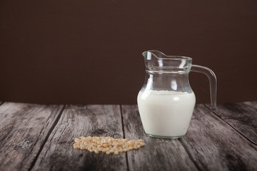 Vegetarian pine nut milk in a glass jug on a wooden table