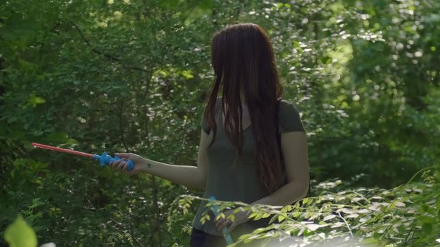 Pretty woman making Colorful Big shimmering Soap Bubbles in the forest. Background Green Trees. Slow Motion. Prores 10Bit mov. Happiness moment.