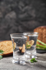 Cold Russian vodka with snacks on grey table, closeup