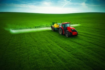 Crédence de cuisine en verre imprimé Tracteur Aerial view of farming tractor plowing and spraying on field