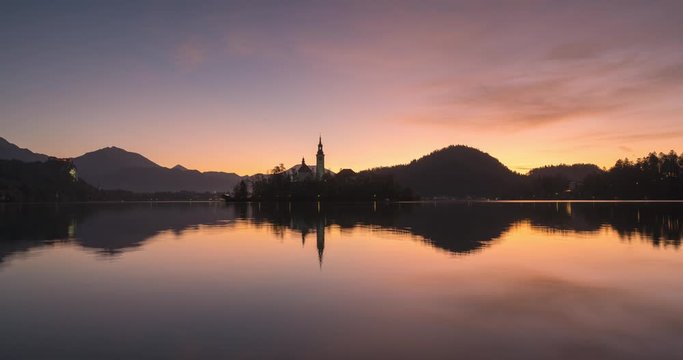 4K Timelapse view of the colorful forest and Lake Bled with a small island with a church. Sunrise in Slovenia in the fall.