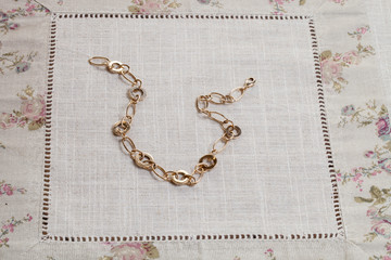 Collier doré posé sur une nappe