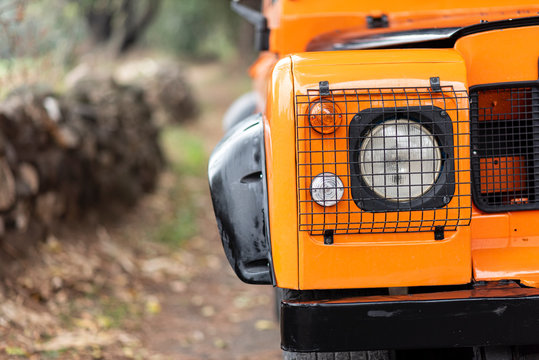 Vintage orange color 4x4 off-road car, the car is old and has been modified. - Powered by Adobe