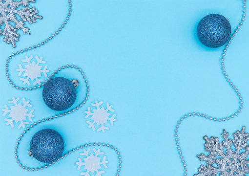 Holiday Background, White Snowflakes, Blue Christmas Balls With Sparkles, Silver Snowflakes And Silver Beads On A Gentle Blue Background ,flat Lay, Top View. Christmas Flatlay Copyspace.