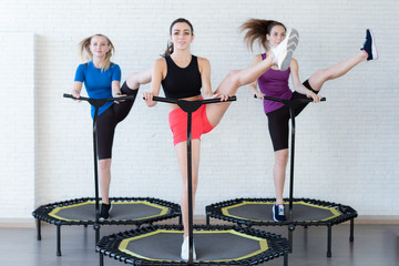Relaxed woman jumping on trampoline.young fitness girl trains on a mini trampoline in the Studio