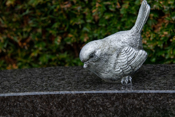 kleiner Vogel auf einem Grabstein