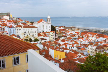 Fototapeta premium Lisbon, Portugal - May, 23rd, 2018 : Alfama district overview and Saint Stephen Church (Santo Estevao) as seen from the Miradouro de Santa Luzia viewpoint.