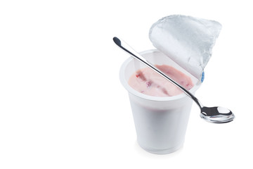 Yoghurt flavored strawberry in an open plastic Cup with a beautiful elegant spoon isolated on a white background.
