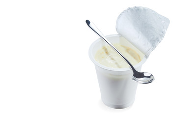Yoghurt flavored banana in an open plastic Cup with a beautiful elegant spoon isolated on a white background.