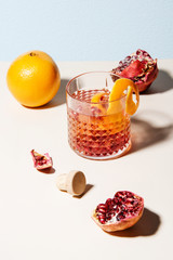 Decorated summer cocktail with fresh pomegranate, orange and lemon slices.Abstract studio conception.