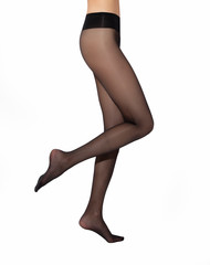 Legs of young caucasian woman in black nylon tights on white background
