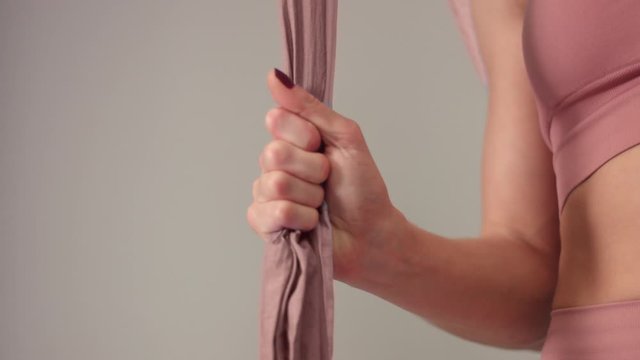 closeup of female hand touching a tissue. Aerial yoga closeup of female hand touching a hammock
