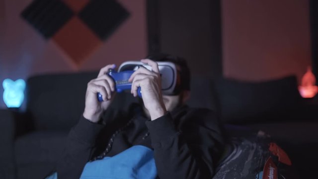 Young man playing with controller and VR glasses