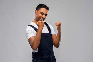profession, construction and building - happy smiling indian worker or builder celebrating success...