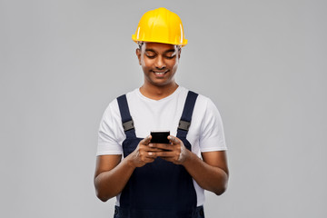 profession, construction and building - happy smiling indian worker or builder in helmet using...