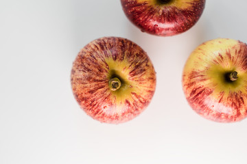 Fresh red yellow striped apples with water droplets on a white glossy kitchen table. Tasty bright juicy fruits. Healthy eating Isolated object	
