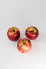 Fresh red yellow striped apples with water droplets on a white glossy kitchen table. Tasty bright juicy fruits. Healthy eating Isolated object	