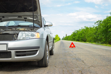 Car with problems and a red triangle to warn other road users