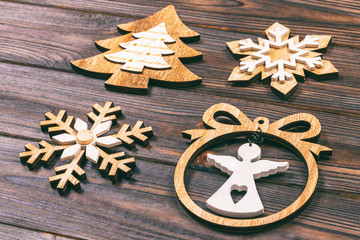 Christmas snowflakes, Christmas tree and angel in a frame on a wooden background. New Year wooden decorations. Toned