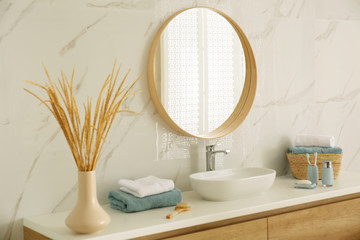 Round mirror over vessel sink in stylish bathroom - Powered by Adobe